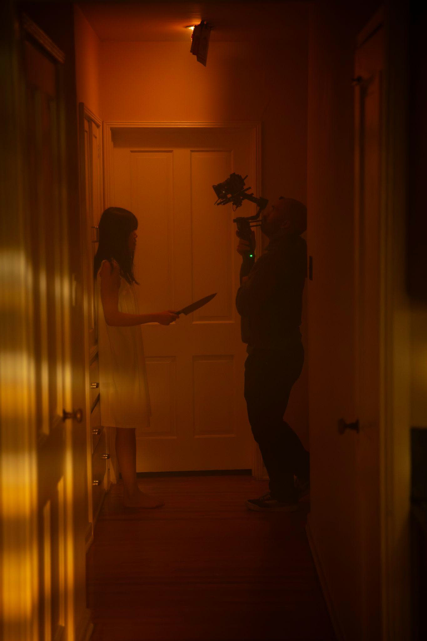 Blocking a hallway scene under warm practical light.