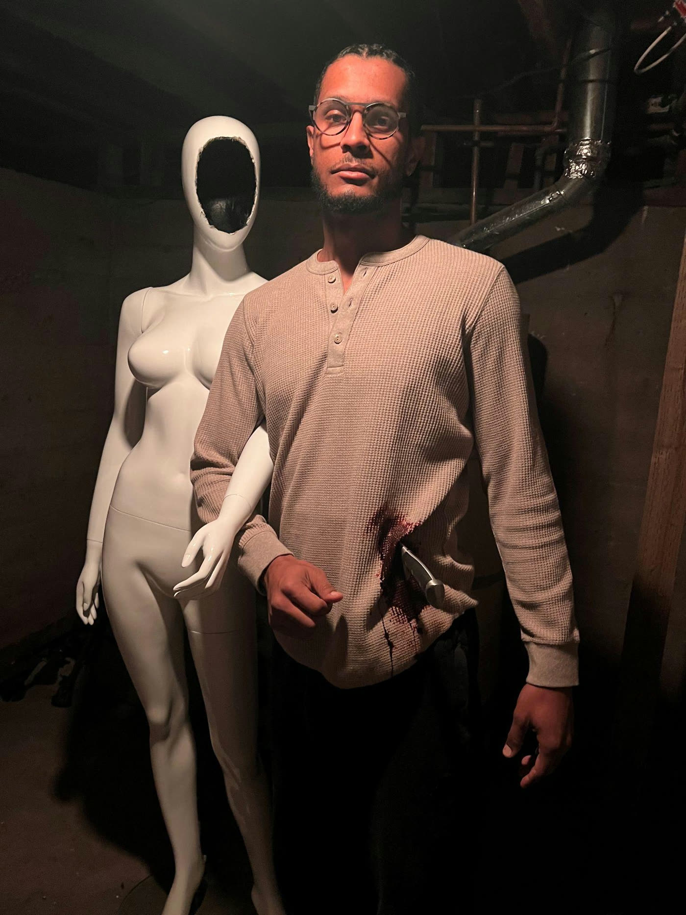 The mannequin gets carried through the basement.